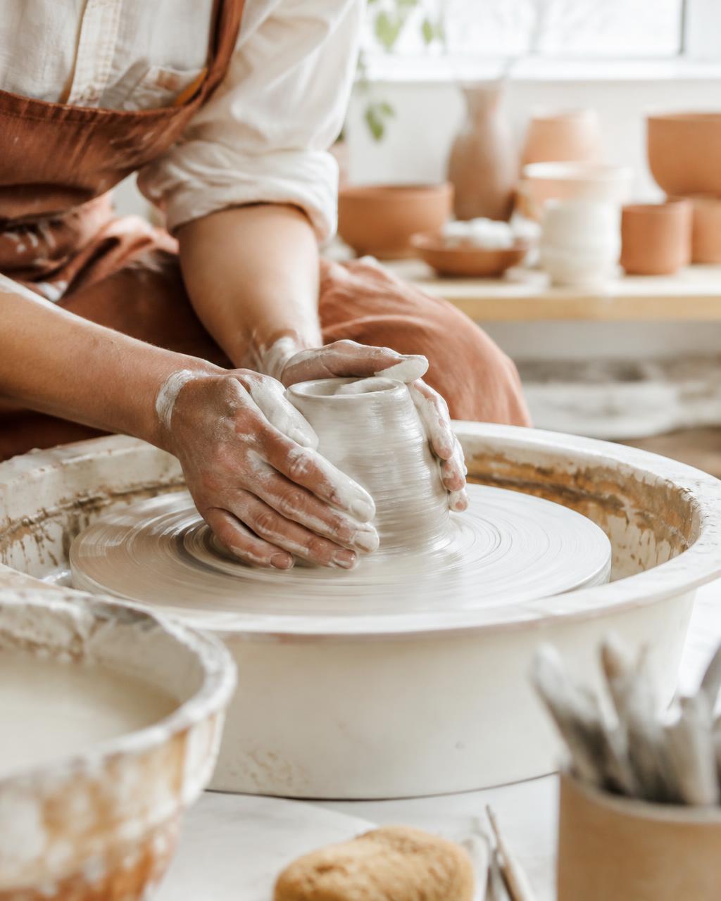 Ceramic artist shaping clay on a pottery wheel